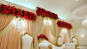 White and golden wedding sofa and chairs decorated with the red flowers, furniture at the wedding ceremony in the restaurant or venue. Move camera - Powered by Shutterstock - Get 15% off with code: PIKWIZARD15