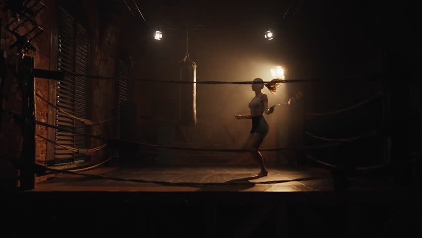 Sport and fitness, athletic woman training in night in boxing ring, jumping rope . Active pastime for stay healthy and slender, lose weight and keep fit, professional sportswoman developing endurance