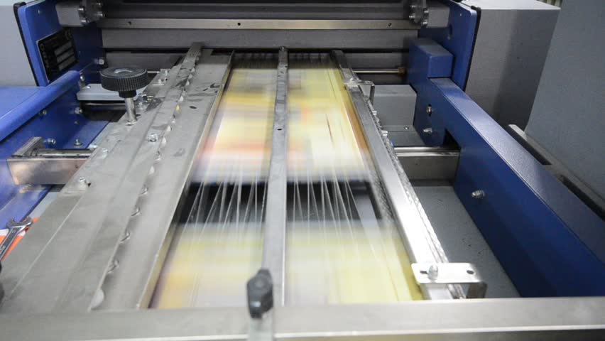 folding machine folds printed offset sheet as part of newspaper brochure in