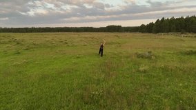 Aerial view of Woman making flow stretching yoga on the grass at sunset. Orbit shot, Uruguay, Punta del Diablo. - Powered by Shutterstock - Get 15% off with code: PIKWIZARD15