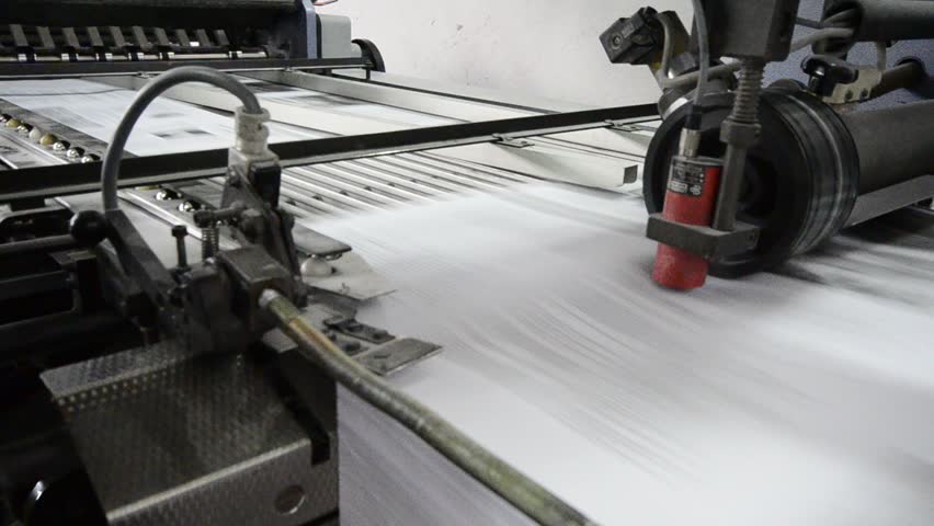 folding machine folds printed offset sheet as part of newspaper brochure in