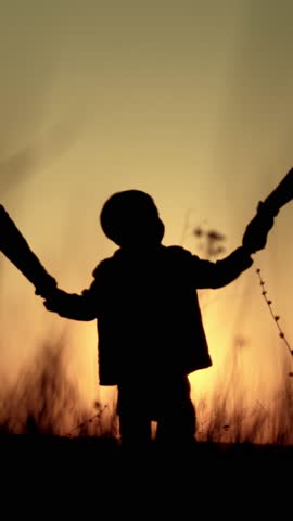 Happy childhood moments, little boy walking in nature with mom and dad, back view, silhouette. Family time in summer vacation and holidays, admiring beautiful sunset or sunrise, slow motion shot