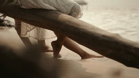 Closeup shot of a waves hitting legs of a couple sitting beside seashore on beach. - Powered by Shutterstock - Get 15% off with code: PIKWIZARD15