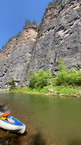 Immerse in natures serenity on a peaceful river, surrounded by rocky cliffs and greenery. Its ideal for outdoor enthusiasts and nature lovers seeking adventure and unique exploration