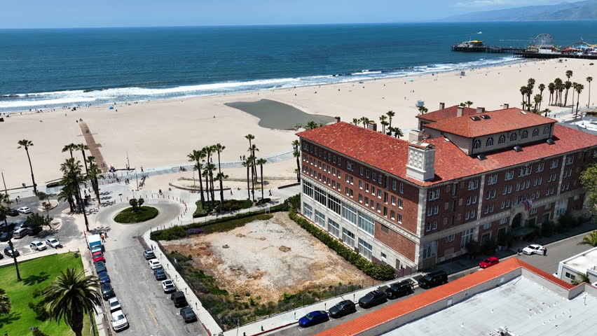 Drone circling buildings along the Boardwalk in Santa Monica, sunny day in LA