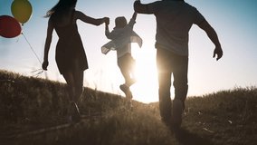 Carefree little boy holding hands of parents when walking in summer day in field . Man and woman lifting up his son, back view in countryside, happy family enjoy simple life, unforgettable moments - Powered by Shutterstock - Get 15% off with code: PIKWIZARD15