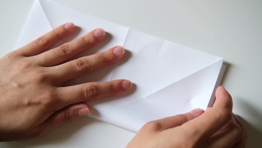 Folding a paper origami white crane, close-up. DIY concept