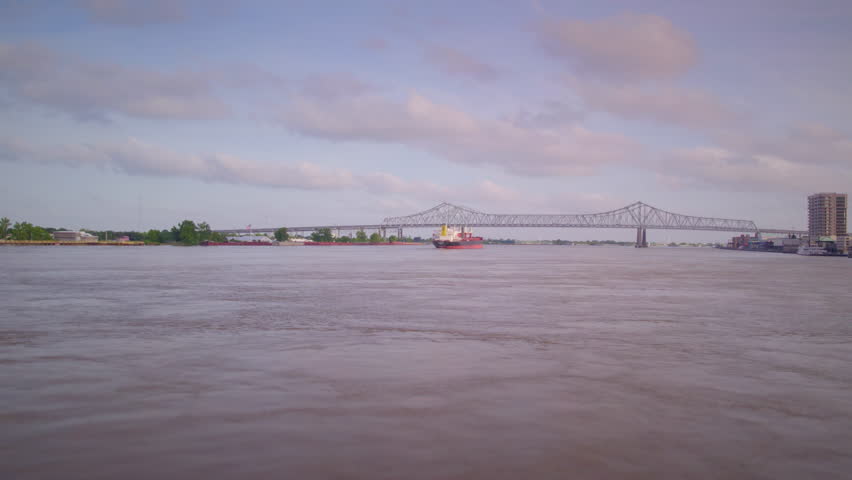 Follow behind a tanker ship moving towards bridge on the Mississippi River