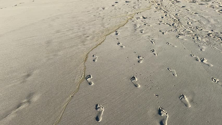 Footprints in the sand on a beach in Camps Bay, Cape Town.