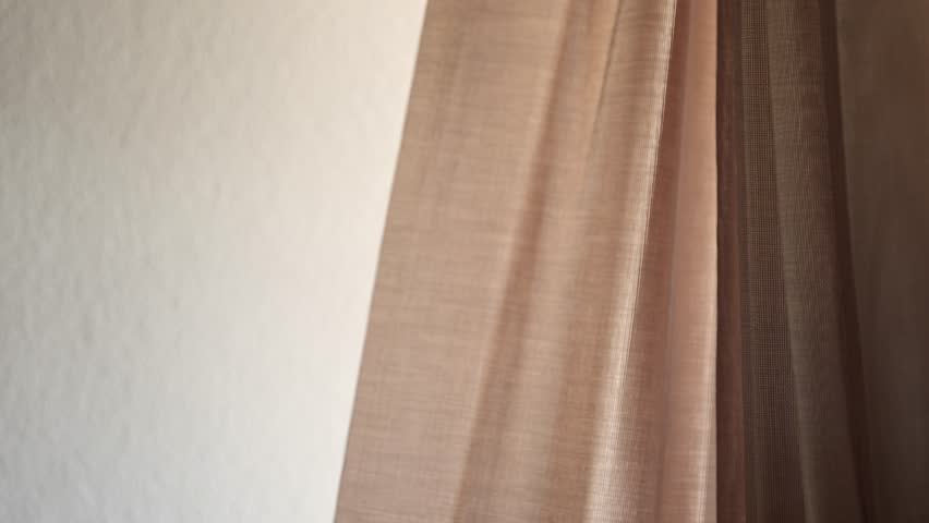 Window curtains swaying in breeze from the open balcony door in summer, 4K slow motion with selective focus