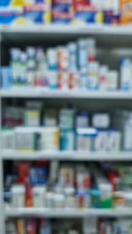 Blurred view of pharmacy stocked shelves. Healthcare and cosmetics industry defocused background
