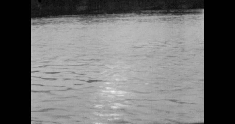 River surface against the background of trees and the setting sun. Archival video, 1970s, Ukraine.