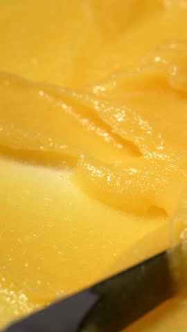 Vertical Screen: Abstract yellow sugar body exfoliating scrub texture. Melon scrub for body or face pilling. Skin care body moisturizer scrub background.