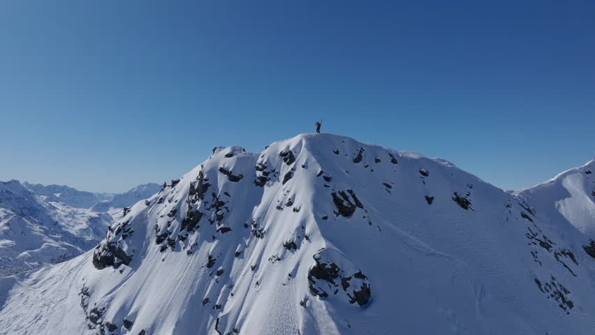 A professional skier hikes up a steep ridge in Verbier, then drops into an epic freeride descent. Pure adventure skiing in deep snow, dramatic terrain, and breathtaking alpine scenery.