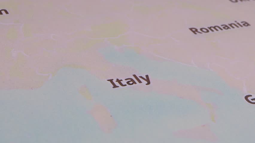 Close-up of a red pushpin marking the location of Italy as part of travel destination.

