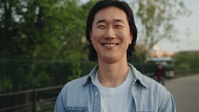 Happy Asian man portrait outdoor in the city park. Young Korean guy cheerful male person looking smiling to camera  - Powered by Shutterstock - Get 15% off with code: PIKWIZARD15