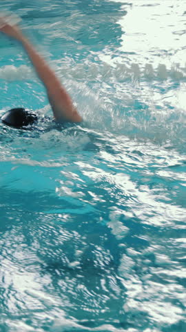 Swimmer splashing in pool lane, Swimmer creating splashes while practicing in a pool lane