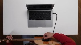 top view Musician recording acoustic guitar with laptop at home studio - Powered by Shutterstock - Get 15% off with code: PIKWIZARD15