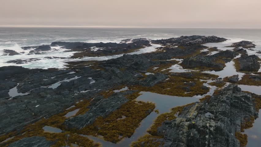 This footage captures a rocky coastline with igneous and metamorphic rocks, highlighting natural geological formations shaped by magma solidification and metamorphic transformation.