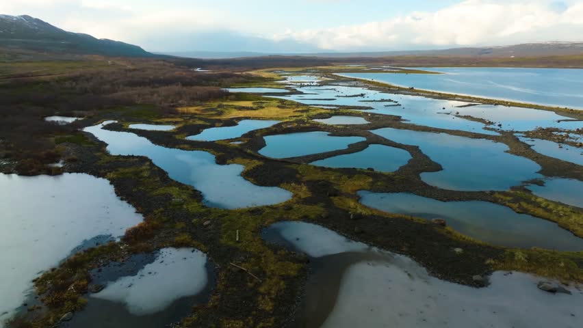 Drone footage captures a tidal marsh at Yakorny Bay, Guba Malaya Volkovaya—a coastal wetland regularly flooded and drained by tidal movements, supporting diverse ecosystems.