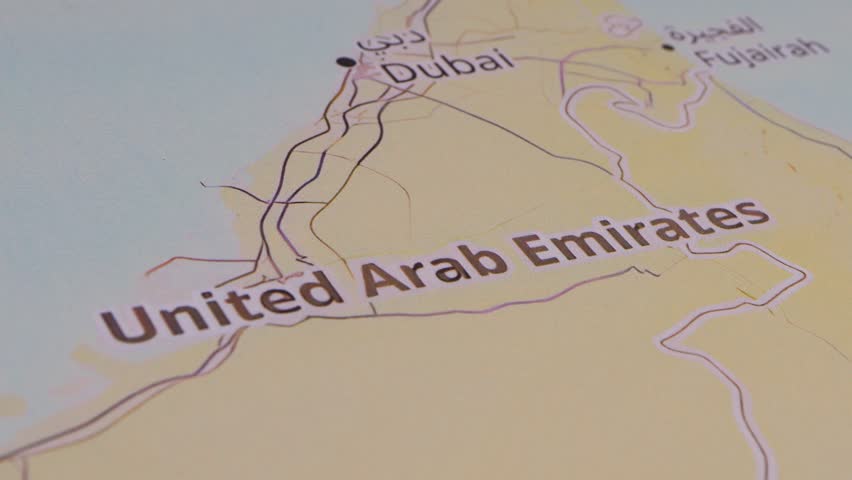 Close-up of a map of the Middle East with a red pushpin marking the United Arab Emirates as part of a travel destination.
