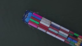 Cargo ship with red, green, blue and yellow containers cuts a dark ribbon through the Puttershoek channel under soft evening light with its geometric pattern, top down overhead drone shot - Powered by Shutterstock - Get 15% off with code: PIKWIZARD15