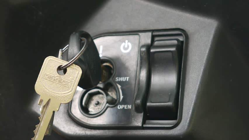 A hand turning the key to lock a matic (automatic) scooter manually