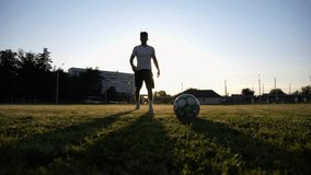 Silhouette of sportsman shooting a penalty kicks on stadium at sunset. Professional footballer kicking soccer ball at green field. Young man training at meadow. Concept of a freestyle football - Powered by Shutterstock - Get 15% off with code: PIKWIZARD15