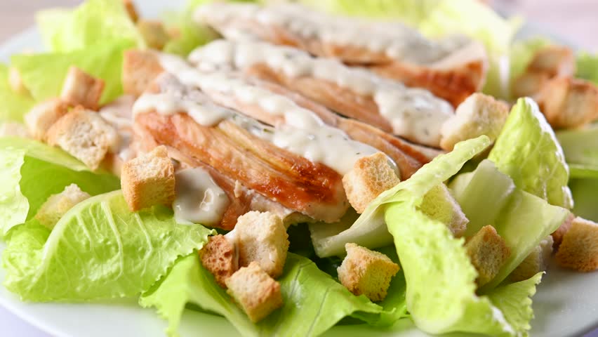 Rotating Classic Caesar Salad	with chicken on wooden table