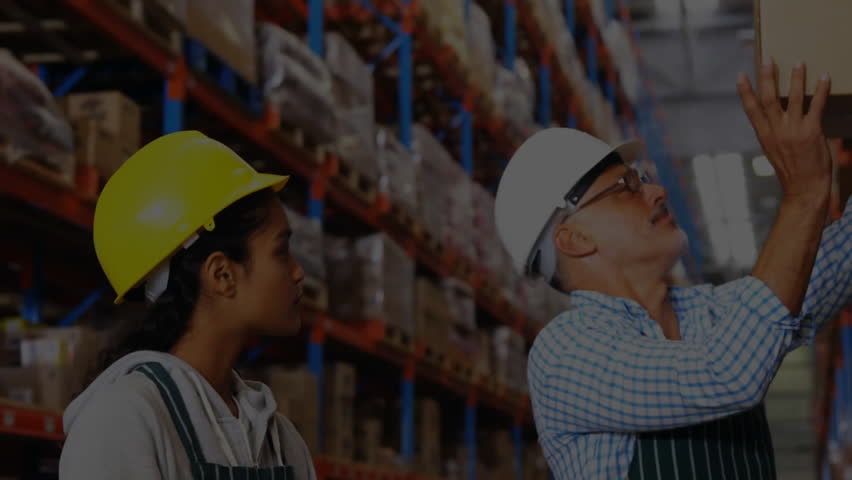 Logistics worker lifting box and noting inventory data while causing holographic interface swirling. Industrial, teamwork, innovation, technology, efficiency, productivity, warehouse - Powered by Shutterstock - Get 15% off with code: PIKWIZARD15