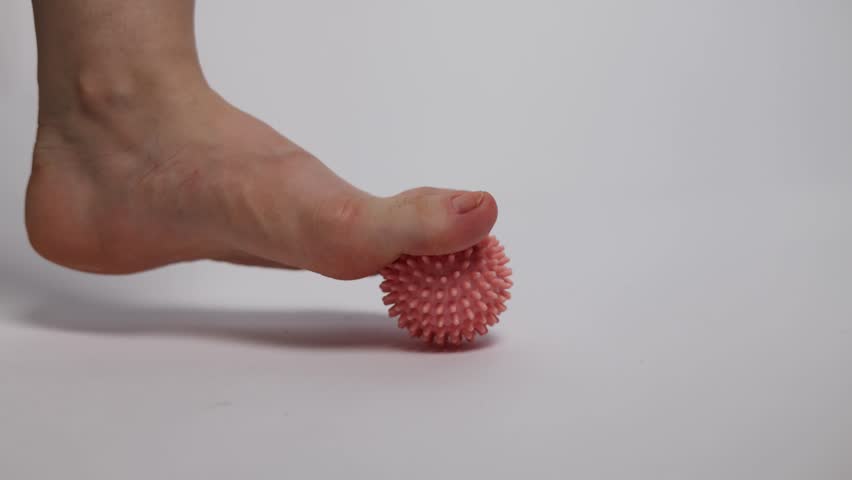 Woman is training with foot massage ball from muscle pain and stress. Relaxation massage after hard work day. 