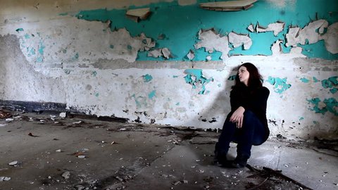 Sad woman in an old abandoned building                          

