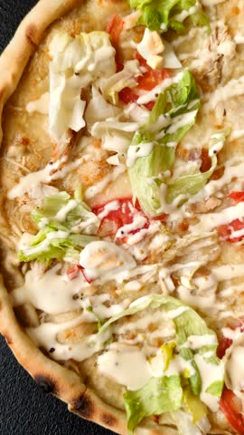 Italian caesar pizza with cheese and chicken, lettuce leaves and sauce. Fast food, sliced pizza