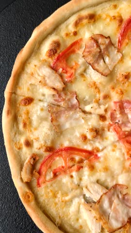 Italian pizza with chicken and bacon, cheese, tomatoes and sauce. Fast food, sliced pizza