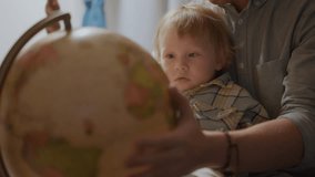 Boy Playing With Globe with father. Little kid Looking at lighting sphere, happy time with daddy. Exploring World, Learning. Child care, sweet time before going sleep. Concept of family and childhood. - Powered by Shutterstock - Get 15% off with code: PIKWIZARD15