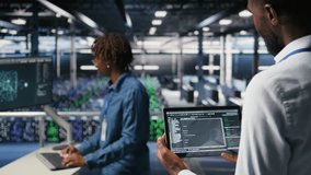 Data center admin checking code on tablet next to colleague reviewing AI visualizations in blurry background. IT experts use device to analyze neural networks outputs, ensuring stable gear operations - Powered by Shutterstock - Get 15% off with code: PIKWIZARD15