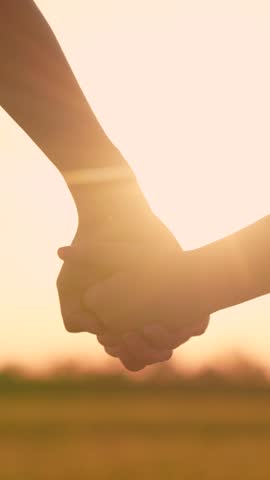 Separation, separation, quarrel. Close-up mother lets go of hand of child girl, separation. Separation of hands of child and mother. Family at sunset. Family mother child spread hands in front of sun.