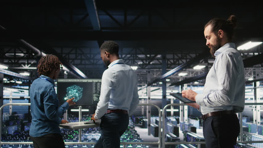 Data center computer scientists using devices to review AI LLM visualizations. Server hub engineering team working to analyze neural networks outputs, ensuring stable gear operations