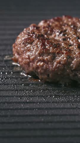 fresh ground beef burger meat patty cooking on hot grill, food closeup
