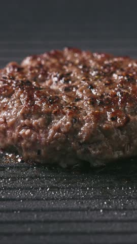 fresh ground beef burger meat patty cooking on hot grill, food closeup