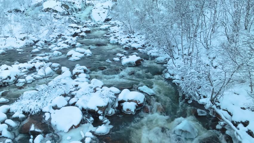 Titovka River captured in icy stillness, with thick snow, frozen banks, and winter textures across a serene northern setting.