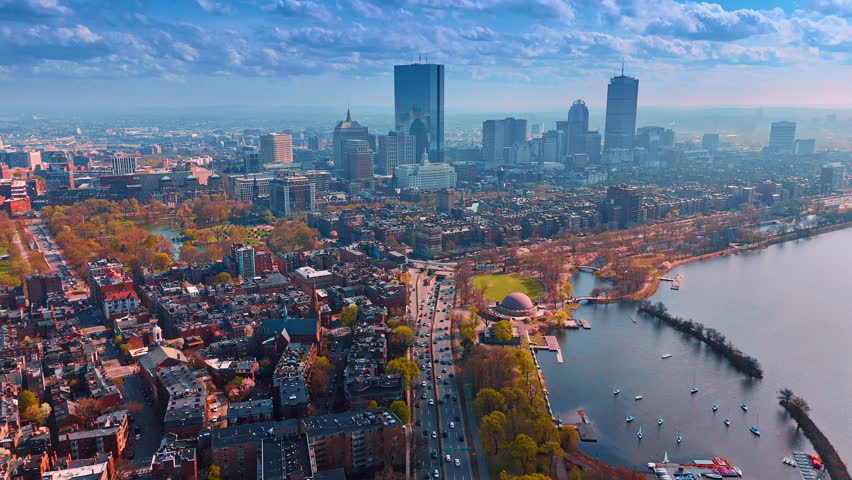 Vast panorama of modern Boston, Massachusetts, USA under the cloudy sky. Approaching highways with heavy traffic. Aerial perspective.