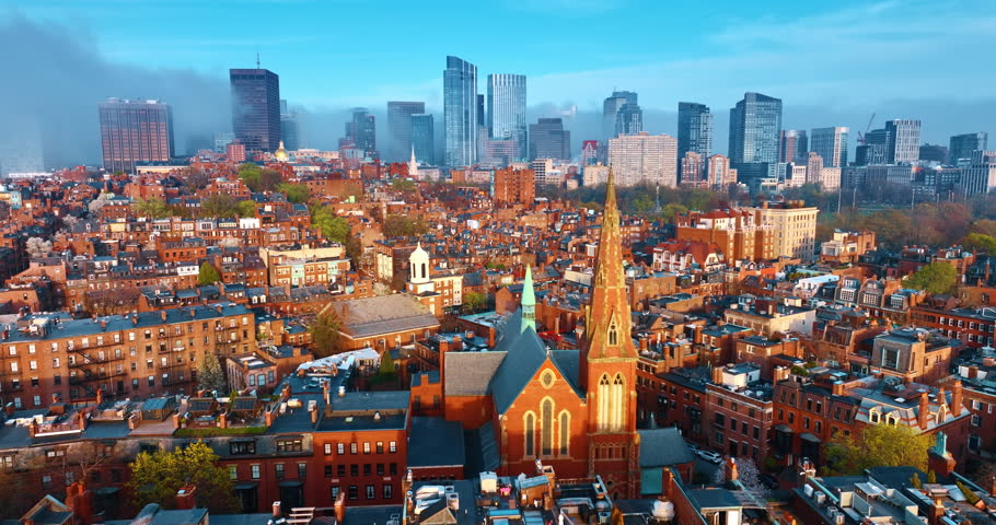 Orange buildings of the old district of Boston, Massachusetts, USA. Skyscrapers at backdrop are coated in smoke. Aerial perspective.