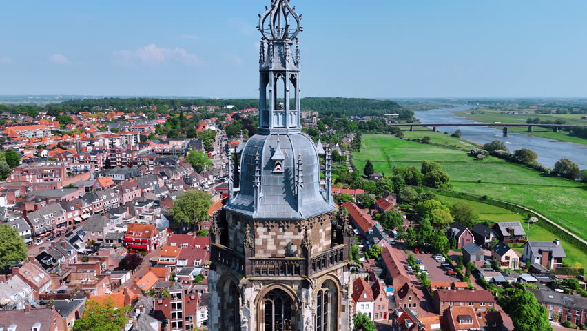 Rising over the top of the Cunera Church revealing view on the beautiful scenery of city of Rhenen, Province Utrecht, the Netherlands. Bridge over the river at backdrop.