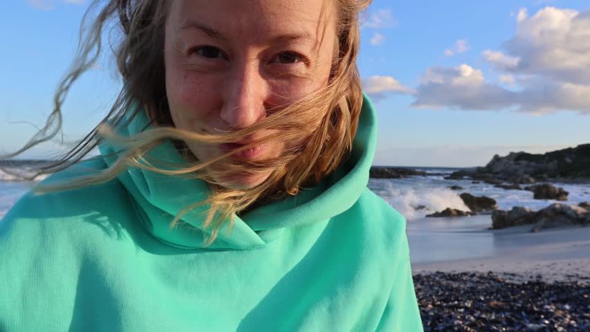 Woman playing with Seashells on Sandy Ocean Shoreline
