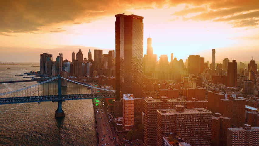 Amazing golden hour in modern New York. Sunset time footage from drone. Setting sun dazzles the scenery.