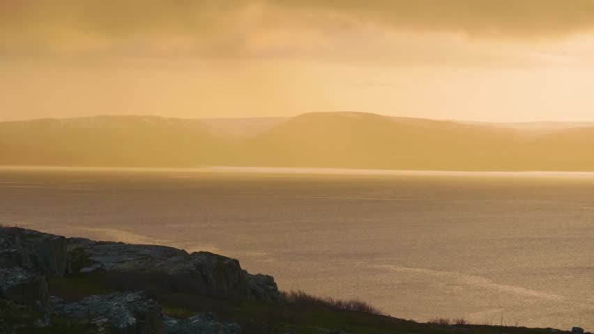 Dramatic sunset at Lake Baikal with intense warm colors painting the sky and reflecting on Siberia’s largest freshwater lake’s tranquil surface.
