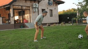 Family enjoying soccer game together, father and son playing passionately on grassy backyard lawn during sunny summer day - Powered by Shutterstock - Get 15% off with code: PIKWIZARD15