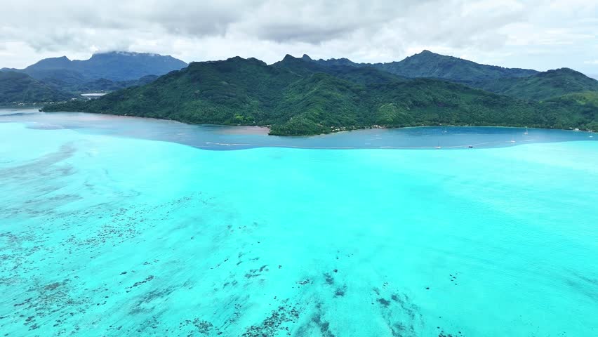 Drone Tahiti. Aerial view of Huahine island lagoon, coastal landscape. Crystal clear blue water. Exotic travel vacation, romantic honeymoon, tourism destination in French Polynesia. 
