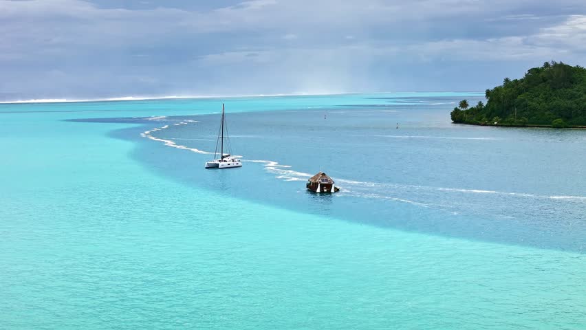 Drone Tahiti. Aerial view of Huahine island lagoon, palm trees and mountains, clear ocean water in French Polynesia. Exotic travel, romantic honeymoon destination in French Polynesia. 